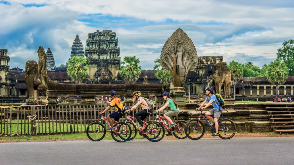 Golden sunrise behind Angkor Wat silhouette reflected in water, Cambodia