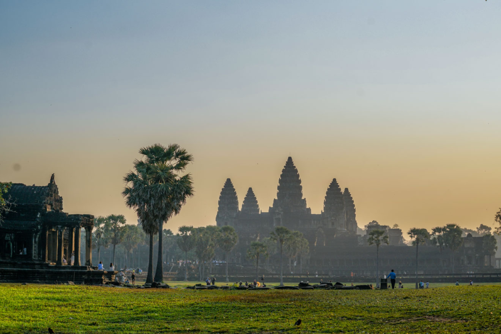 Angkor Wat sunrise bike tour — cyclists at the reflection pond, Siem Reap Cambodia